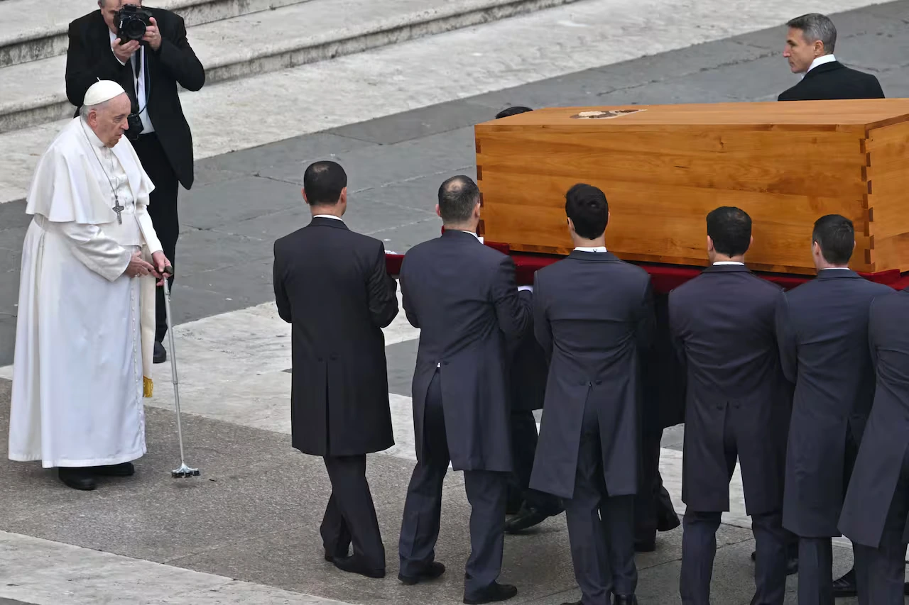 Los portadores del féretro llevan el ataúd del Papa Emérito Benedicto XVI frente al papa Francisco al final de su misa fúnebre en la plaza de San Pedro en el Vaticano, el 5 de enero de 2023